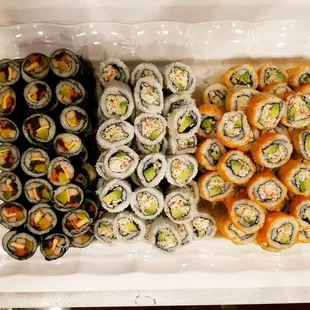 a tray of sushi and rolls