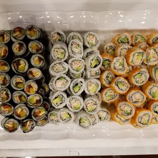 a tray of sushi and rolls