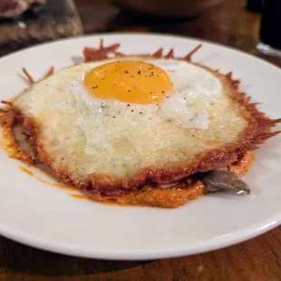 Queso Frito. $13. Fried farm egg and manchego, romesco, lion&apos;s mane mushrooms.