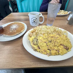 Meat omelette with mushrooms, hash browns with grilled onions and pancakes.