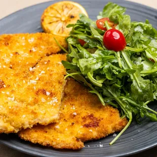 Chicken Milanese - 
Sautéed &amp; breaded pounded flat chicken cotelette, served with arugula, tomatoes, roasted potatoes