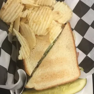 a pickle and potato chips in a basket