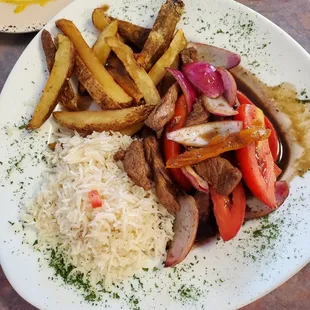 Steak over rice and French fries