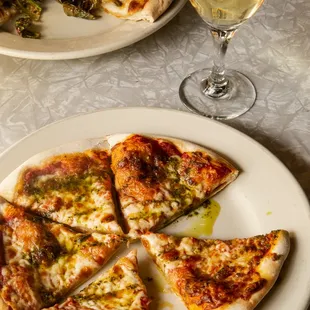 a plate of pizza and a glass of wine