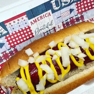 a hot dog with mustard and onions