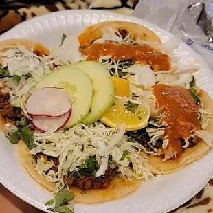a person holding a plate of tacos