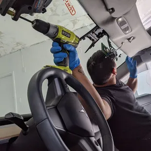 Tesla windshield being cut out with nylon cord.