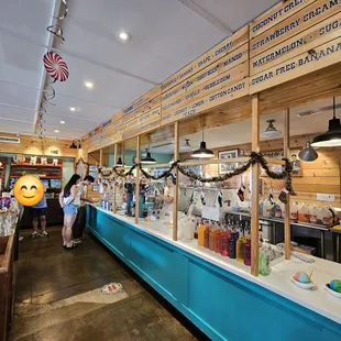 Inside the shop. Area to order shave ice. Along with some merchandise. More merchandise on the right-hand side.