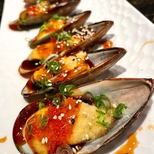 a plate of steamed mussels with sauce