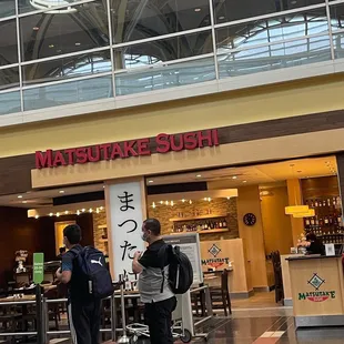 two people standing in front of a restaurant