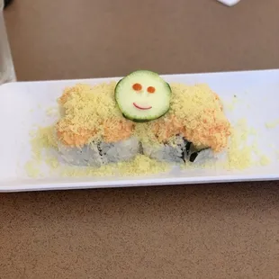 Volcano roll topped with an adorable cucumber happy face