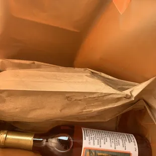 a bottle of wine in a paper bag