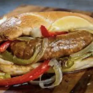 Grilled sausage with peppers and onions on a potato roll.