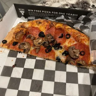 Half of a small pizza with mushrooms, olives and pepperoni.