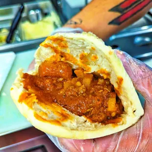 a hand holding a pita sandwich