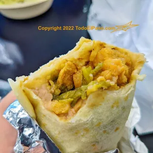 a hand holding a burrito