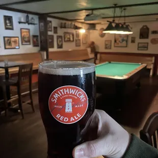 a person holding a pint of beer