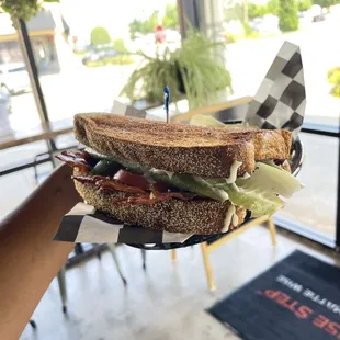 a person holding a sandwich