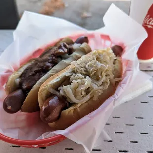 two hot dogs with sauerkraut and onions