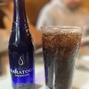 a bottle and a glass of soda