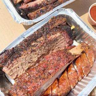 two trays of ribs and sausage