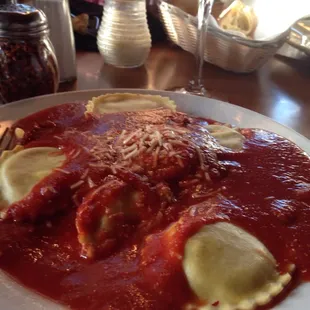 a plate of ravioli with sauce and cheese