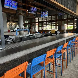 a bar with blue and orange chairs