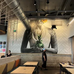 a mural of a woman holding a plant