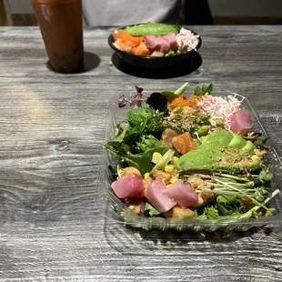 a man sitting at a table with a salad and a drink