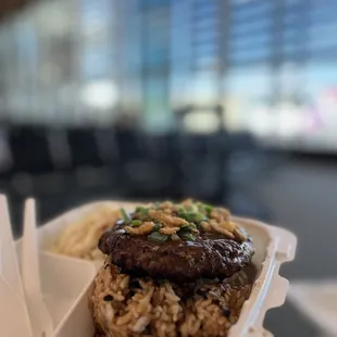 a hand holding a container of food