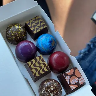 a hand holding a box of chocolates