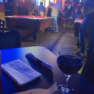 a pool table and a glass of wine