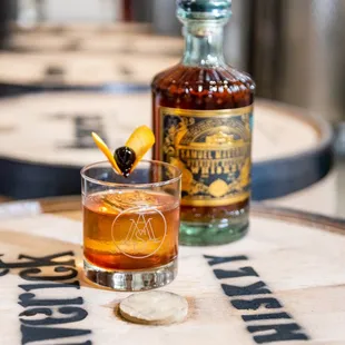 a glass of whiskey and a bottle of bourbon