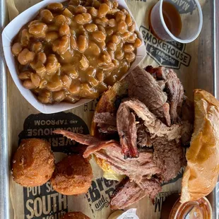 Brisket sandwich with baked beans and hush puppies