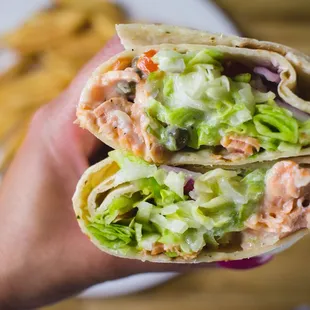 a hand holding a burrito