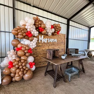 Wood setup including wood table ,2 wooden crates ,3 metal trays , Balloons are always based on the theme .