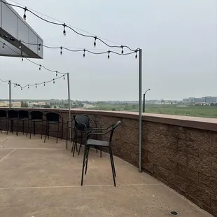 a patio area with chairs and string lights