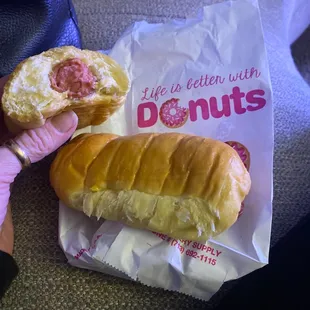 a person holding a donut and a bag of donuts