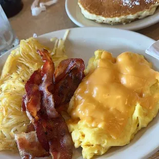 Bacon, hashbrowns, eggs with American cheese and pancakes.