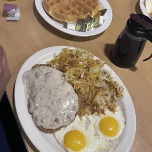 Country fried steak, eggs and hash browns.