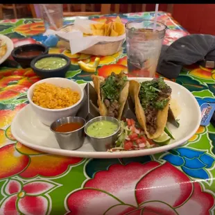 Two tacos with a side of rice