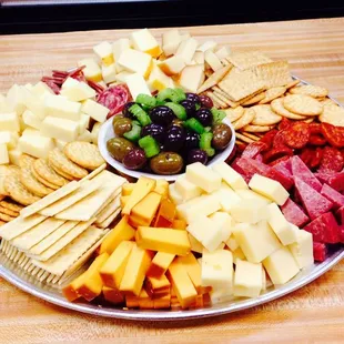 a platter of cheese, crackers, and olives