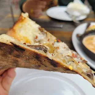 Side view of mushroom thin crust pizza. Had a nice char and texture.