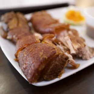 meat on a plate with a side of sauce