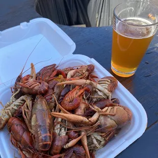 a plate of lobsters and a glass of beer