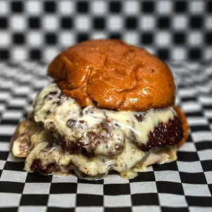 a cheeseburger on a checkered table cloth