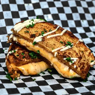 a grilled cheese sandwich on a checkered table cloth