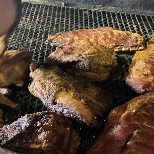 a person cooking meat on a grill