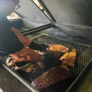 a man cooking steaks on a grill