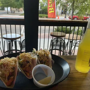 a plate of burritos and a bottle of beer